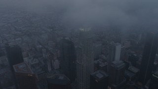 AX44_037 - 4K aerial stock footage of a wide angle descending through marine layer toward Downtown Los Angeles, twilight