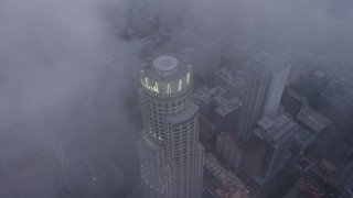 AX44_038 - 4K aerial stock footage of a bird's eye of US Bank Tower through marine layer, Downtown Los Angeles, twilight