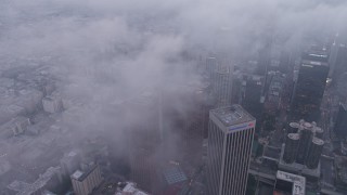 AX44_040 - 4K aerial stock footage of skyscrapers coverd in marine layer, twilight, Downtown Los Angeles