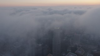 AX44_042 - 4K aerial stock footage of city covered in marine layer, Downtown Los Angeles, sunset