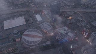 AX44_044 - 4K aerial stock footage of Staples Center and Nokia Theater below marine layer, Downtown Los Angeles, twilight