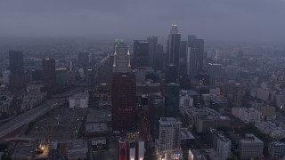 AX44_047 - 4K aerial stock footage of skyscrapers through marine layer, Downtown Los Angeles, twilight
