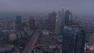 AX44_048 - 4K aerial stock footage approaching skyscrapers below marine layer, Downtown Los Angeles, twilight