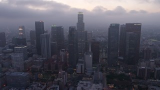 AX44_051 - 4K aerial stock footage of a marine layer hanging over skyscrapers, Downtown Los Angeles, twilight