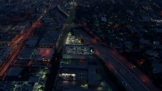 AX44_061 - 4K aerial stock footage flying over light traffic on an interstate, Los Angeles, twilight