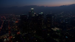 AX44_074 - 4K aerial stock footage flying by skyscrapers tracking US Bank Tower, Downtown Los Angeles, twilight