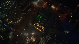 AX44_080 - 4K aerial stock footage orbiting Los Angeles Public Library and tilt down, Downtown, night