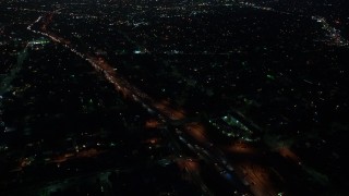 AX44_087 - 4K aerial stock footage orbiting a highway with medium traffic among city light, Echo Park, Los Angeles, night