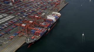 AX45_016E - 5K aerial stock footage approaching a cargo ship loading containers at Port of Seattle, Washington