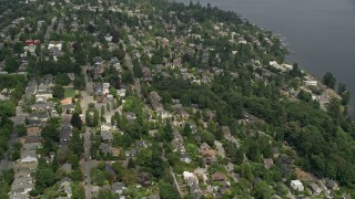 AX45_080E - 5K aerial stock footage flying by residential neighborhood with trees, Madrona, Seattle, Washington