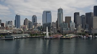AX45_096E - 5K stock footage aerial video flying by skyline, Seattle Ferry Terminal, reveal the Great Wheel, aquarium and Space Needle, Downtown Seattle, Washington