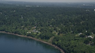 AX45_115 - 5K aerial stock footage tilt from railroad tracks on the shore to reveal homes, Shoreline, Washington