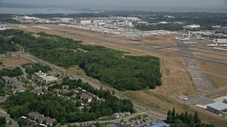 AX45_130E - 5K stock footage aerial video approach the runways of Paine Field, and the Boeing Factory, Everett, Washington