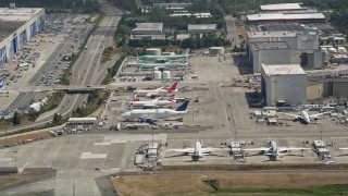 AX45_138 - 5K stock footage aerial video flyby airliners parked at Paine Field and reveal the Boeing Everett Factory, Washington