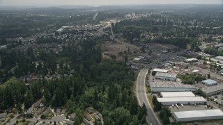 AX46_005 - 5K aerial stock footage follow road between homes and warehouse buildings to approach a mobile homes park, Lynnwood, Washington
