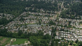 AX46_014 - 5K stock footage aerial video flying by suburban homes around a pond, Brier, Washington