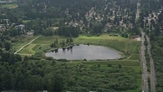 AX46_040 - 5K aerial stock footage approaching Larsen Lake, surrounded by crop fields, Bellevue, Washington