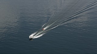 AX46_051 - 5K aerial stock footage track a speedboat towing a raft across Lake Washington, Washington