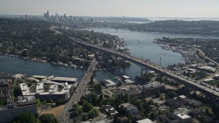 AX47_079E - 5K aerial stock footage fly over an office building, tilt to reveal the bridge, Lake Union, and Downtown Seattle skyline in Washington