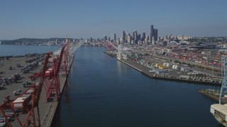 AX47_103 - 5K aerial stock footage flyby cranes and over the Duwamish Waterway at Harbor Island toward Downtown Seattle skyline, Washington