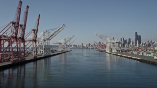 AX47_103E - 5K aerial stock footage flyby cranes and over the Duwamish Waterway at Harbor Island toward Downtown Seattle skyline, Washington