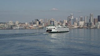 AX47_116E - 5K aerial stock footage descend and flyby a ferry sailing toward the Downtown Seattle skyline, Washington