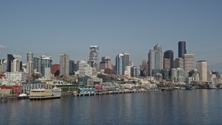 AX47_118E - 5K aerial stock footage of low altitude approach the Seattle Waterfront piers and skyline, Downtown Seattle, Washington