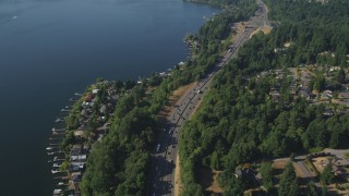 AX48_006 - 5K stock footage aerial video of flying over light traffic on I-405 and lakeside homes with docks, Bellevue, Washington