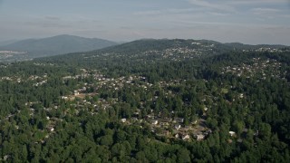 AX48_012E - 5K aerial stock footage of passing hillside suburban homes with lush trees, Bellevue, Washington