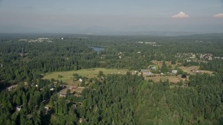 AX48_018E - 5K aerial stock footage fly over lakefront homes with docks and trees, tilt to approach rural homes and Pine Lake, Sammamish, Washington
