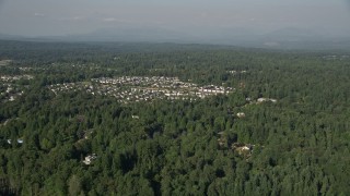 AX48_022 - 5K aerial stock footage fly over lush green trees to approach a small residential neighborhood, Sammamish, Washington