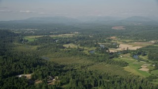 AX48_027 - 5K aerial stock footage approach the Snoqualmie River winding around farmland in Carnation, Washington