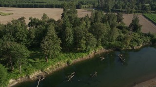 AX48_037 - 5K aerial stock footage fly over the Snoqualmie River to approach farm fields in Carnation, Washington