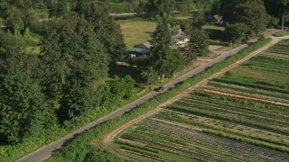 AX48_038 - 5K stock footage aerial video of tracking a sedan traveling on a country road by farmland in Carnation, Washington