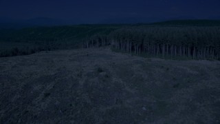 AX48_044_DFN - 4K day for night color corrected aerial stock footage of a clear cut area, pan to approach evergreen forest in King County, Washington