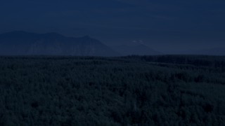 AX48_045_DFN - 4K day for night color corrected aerial stock footage of a clear cut area, evergreen forest, and Cascade Range in King County, Washington