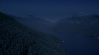 AX48_059_DFN - 4K day for night color corrected aerial stock footage of evergreen trees on mountain slope next to the South Fork Tolt Reservoir, Cascade Range, Washington