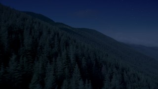 AX48_060_DFN - 4K day for night color corrected aerial stock footage of mountain slopes covered with evergreen trees in the Cascade Range, Washington