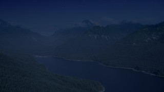 AX48_061_DFN - 4K day for night color corrected aerial stock footage of wooded mountain peaks beside the South Fork Tolt Reservoir, Cascade Range, Washington
