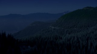 AX48_063_DFN - 4K day for night color corrected aerial stock footage of a mountain ridge and evergreen trees on mountain slopes, Cascade Range, Washington