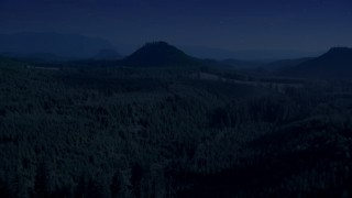 AX48_077_DFN - 4K day for night color corrected aerial stock footage of evergreen forest, reveal a green hill and logging areas in King County, Washington