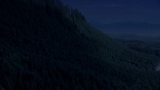 AX48_078_DFN - Aerial stock footage of 4K day for night color corrected aerial footage of approach and pan across a ridge with evergreen trees in King County, Washington