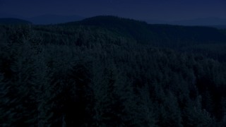 AX48_082_DFN - 4K day for night color corrected aerial stock footage of a vast evergreen forest on a ridge in the Cascade Range, Washington
