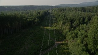 AX49_011E - 5K aerial stock footage of following power lines cutting through a forest, King County, Washington