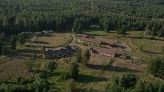 AX49_014 - 5K aerial stock footage of flying by a small ranch on the edge of an evergreen forest, Carnation, Washington
