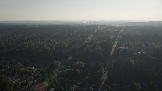 AX49_033 - 5K aerial stock footage of flying over a suburban neighborhood crowded with trees toward Downtown Bellevue, Washington