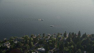 AX49_053 - 5K aerial stock footage fly over lakeside houses to approach fishing boats on Lake Washington, Bellevue, Washington