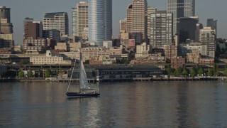 AX49_067E - 5K aerial stock footage track a sailboat raising sail on Elliott Bay, Seattle, Washington
