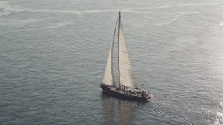 AX49_080 - 5K aerial stock footage track a sailboat on Elliott Bay, reflecting the sunlight, Seattle, Washington