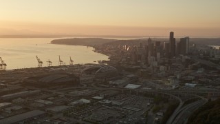 AX50_006E - 5K aerial stock footage approach CenturyLink, Safeco Field, port cargo cranes, and skyscrapers, Downtown Seattle, Washington, sunset